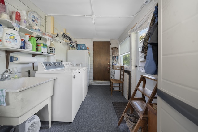 laundry room with washing machine and dryer, dark carpet, and sink