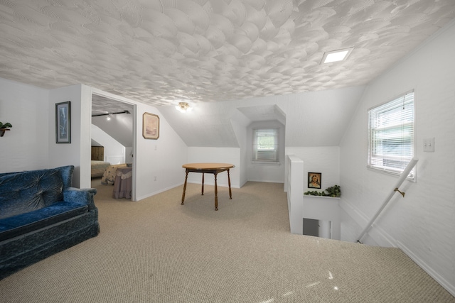 bonus room featuring carpet flooring, a healthy amount of sunlight, and lofted ceiling