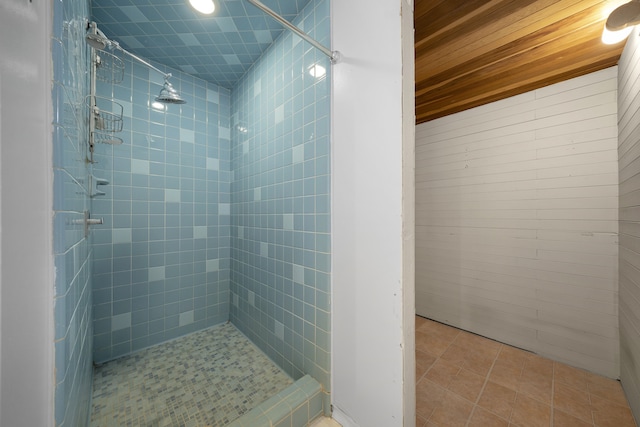 bathroom with tiled shower and tile patterned flooring