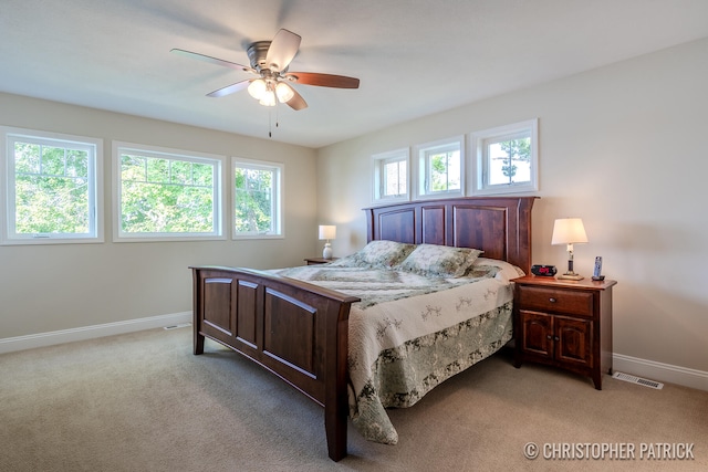 bedroom featuring light colored carpet, visible vents, ceiling fan, and baseboards