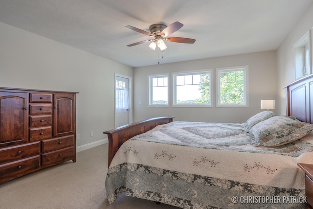 bedroom featuring light carpet, ceiling fan, and baseboards