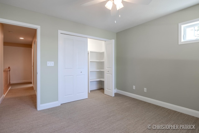 unfurnished bedroom featuring light carpet, ceiling fan, baseboards, and a closet