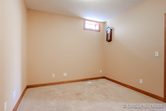 carpeted spare room with visible vents and baseboards