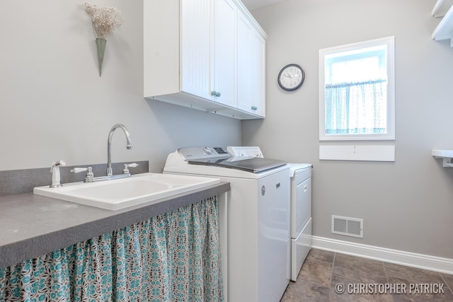 laundry room with cabinet space, baseboards, visible vents, independent washer and dryer, and a sink