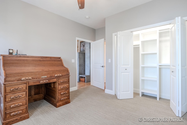 unfurnished office with ceiling fan, baseboards, and light colored carpet