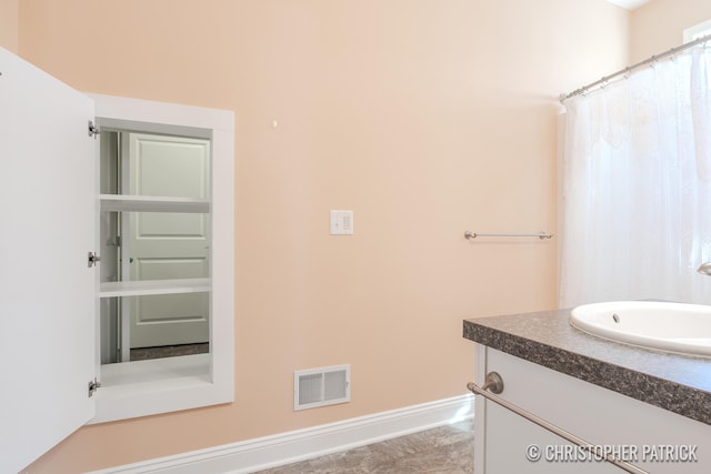 full bathroom with visible vents, vanity, and baseboards