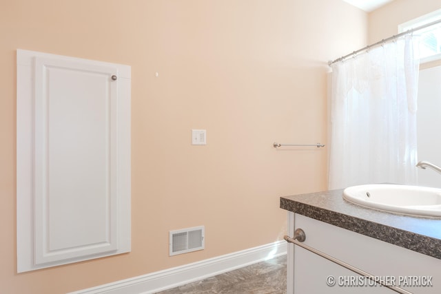 bathroom with curtained shower, baseboards, visible vents, and vanity