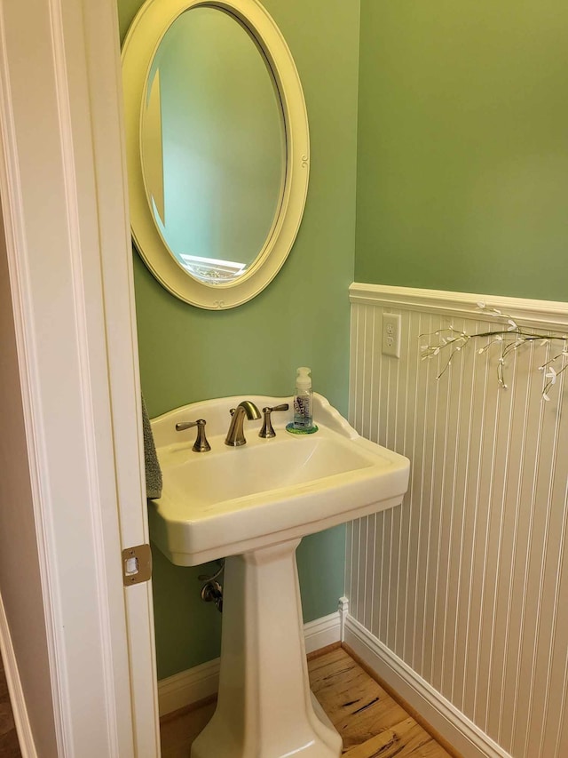 bathroom featuring a sink, baseboards, and wood finished floors