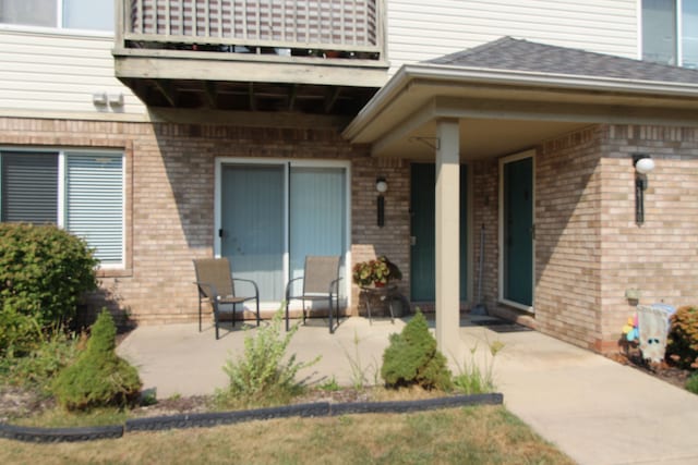 entrance to property featuring a patio and a balcony