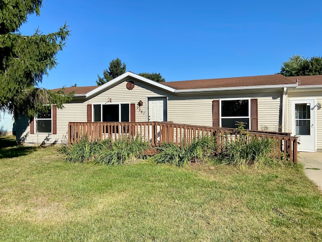 rear view of property featuring a wooden deck and a yard