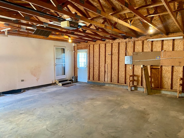 garage with electric panel and a garage door opener