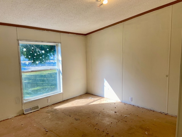 empty room with crown molding and a textured ceiling