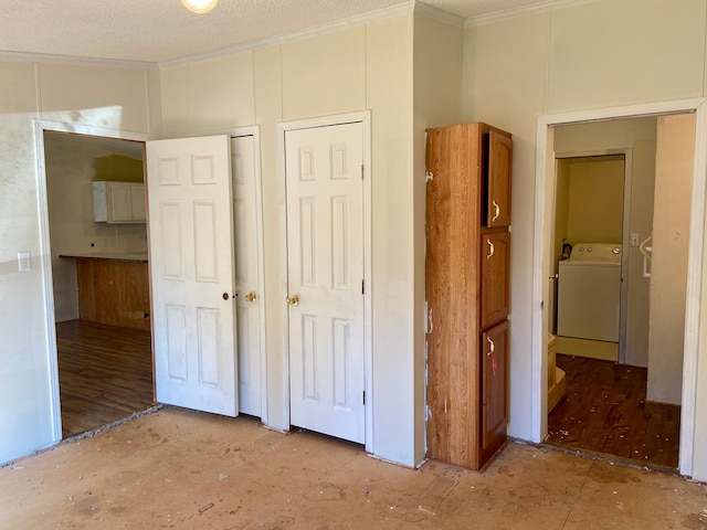 interior space with a textured ceiling, washer / clothes dryer, light hardwood / wood-style flooring, and multiple closets