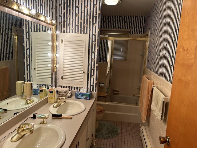 2768 S M-88, Bellaire, MI 49615 - full bathroom with tile patterned floors, vanity, baseboard heating, shower / bath combination with glass door, and toilet
