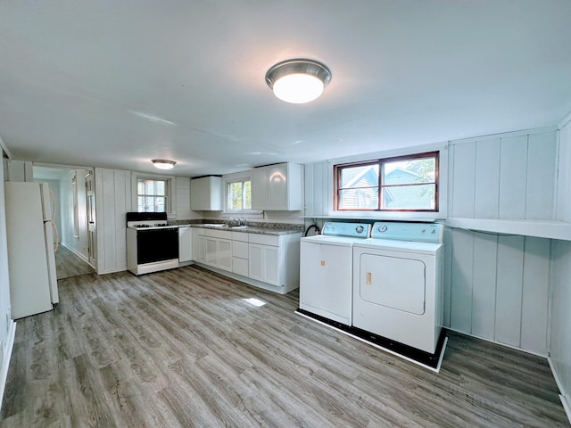 clothes washing area featuring washer and dryer, sink, and light hardwood / wood-style flooring