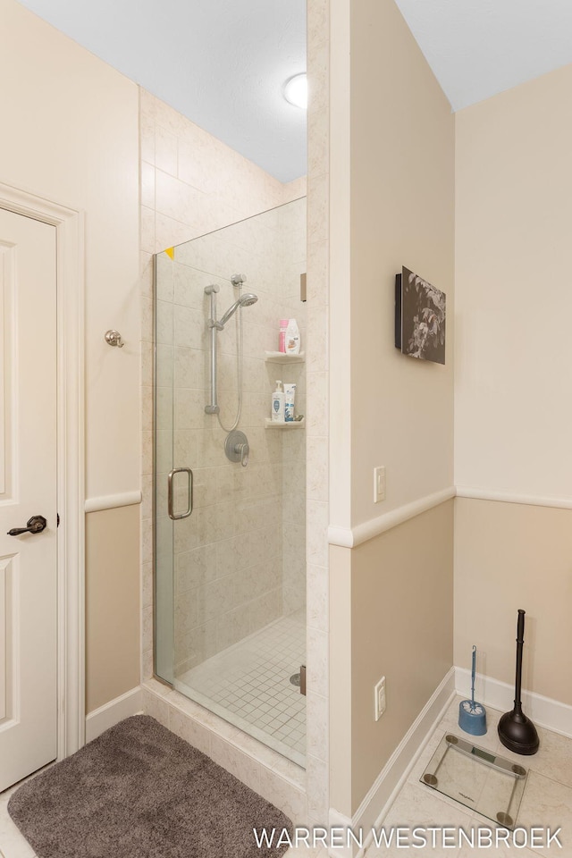 bathroom with tile patterned floors and a shower with door