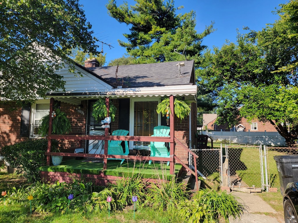 18829 Kelly Rd, Detroit, MI 48224 - bungalow-style home with brick siding, covered porch, a gate, and a chimney