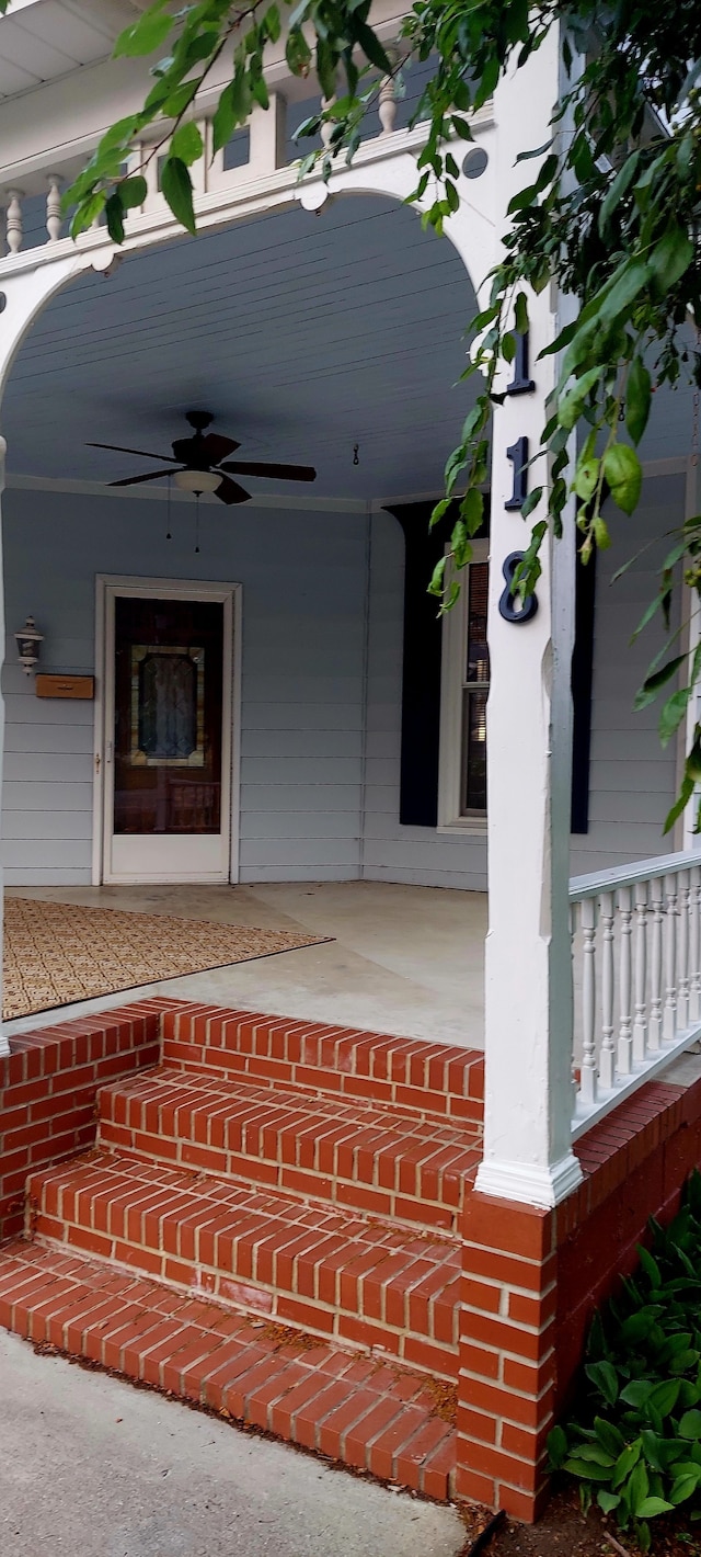 entrance to property featuring a porch and ceiling fan