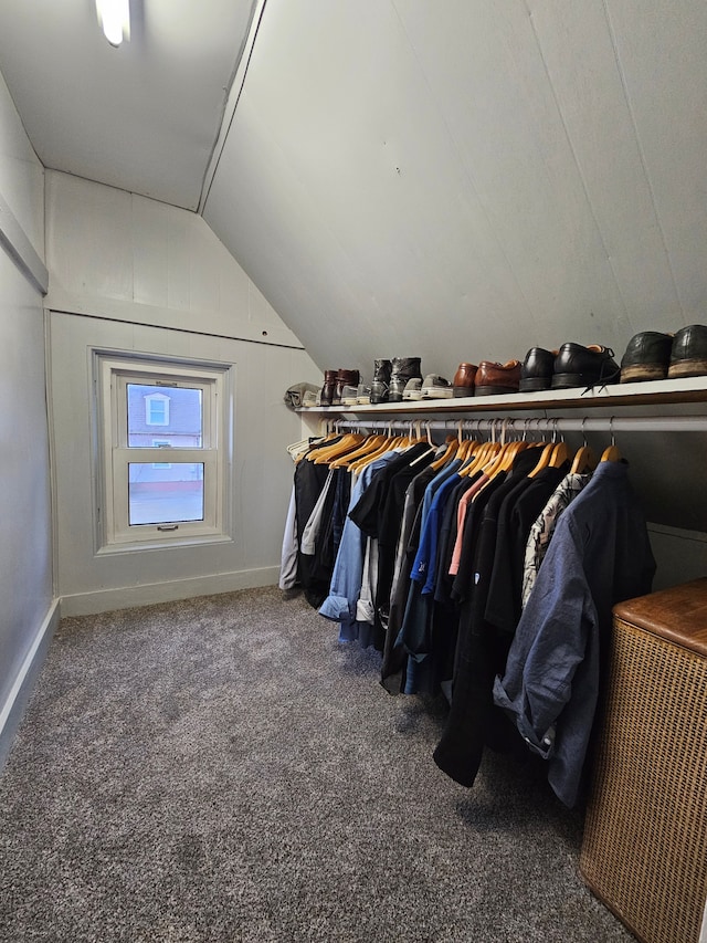 spacious closet with dark colored carpet and lofted ceiling