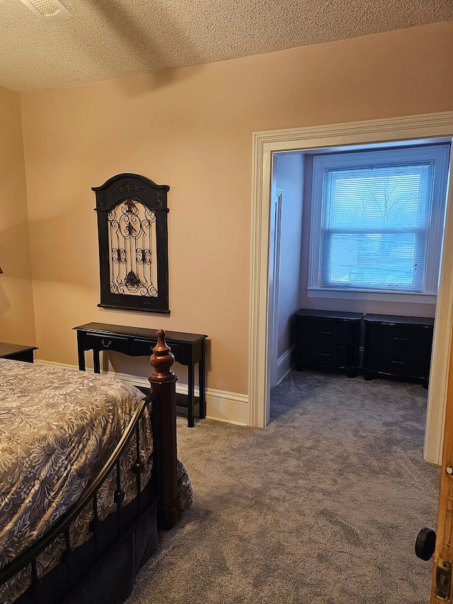 bedroom featuring carpet flooring and a textured ceiling