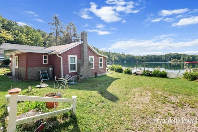 748 Kimberly Dr NE, Sparta, MI 49345 - view of side of home featuring a water view, a chimney, and a lawn
