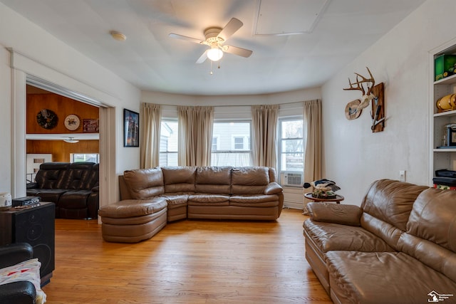 living room featuring light wood-type flooring, built in features, ceiling fan, and cooling unit