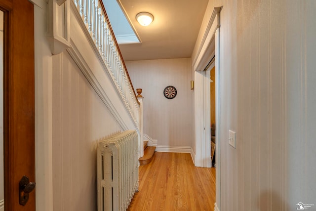 hall with radiator heating unit and light hardwood / wood-style floors