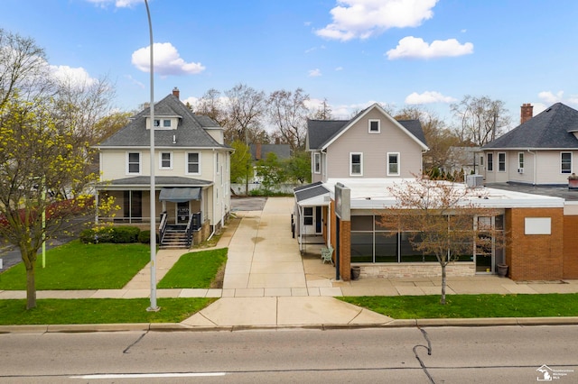 view of front of property featuring a front lawn and central AC unit