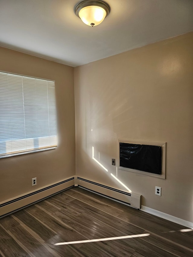 empty room with dark hardwood / wood-style flooring and baseboard heating