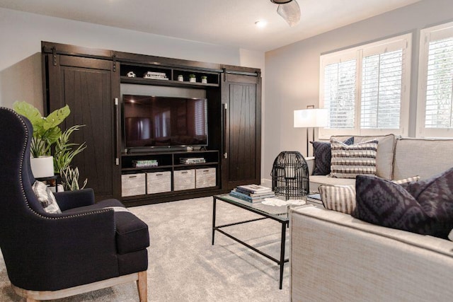 carpeted living room with a barn door