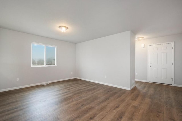 unfurnished room featuring dark hardwood / wood-style flooring