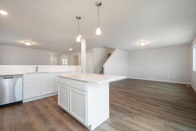 kitchen with sink, decorative light fixtures, dishwasher, a kitchen island, and white cabinets