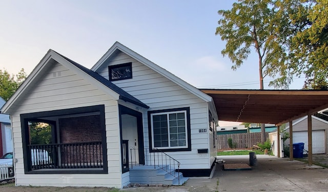 view of front of home featuring an attached carport and an outbuilding