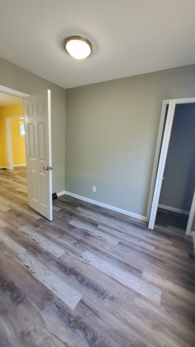 empty room featuring wood finished floors and baseboards