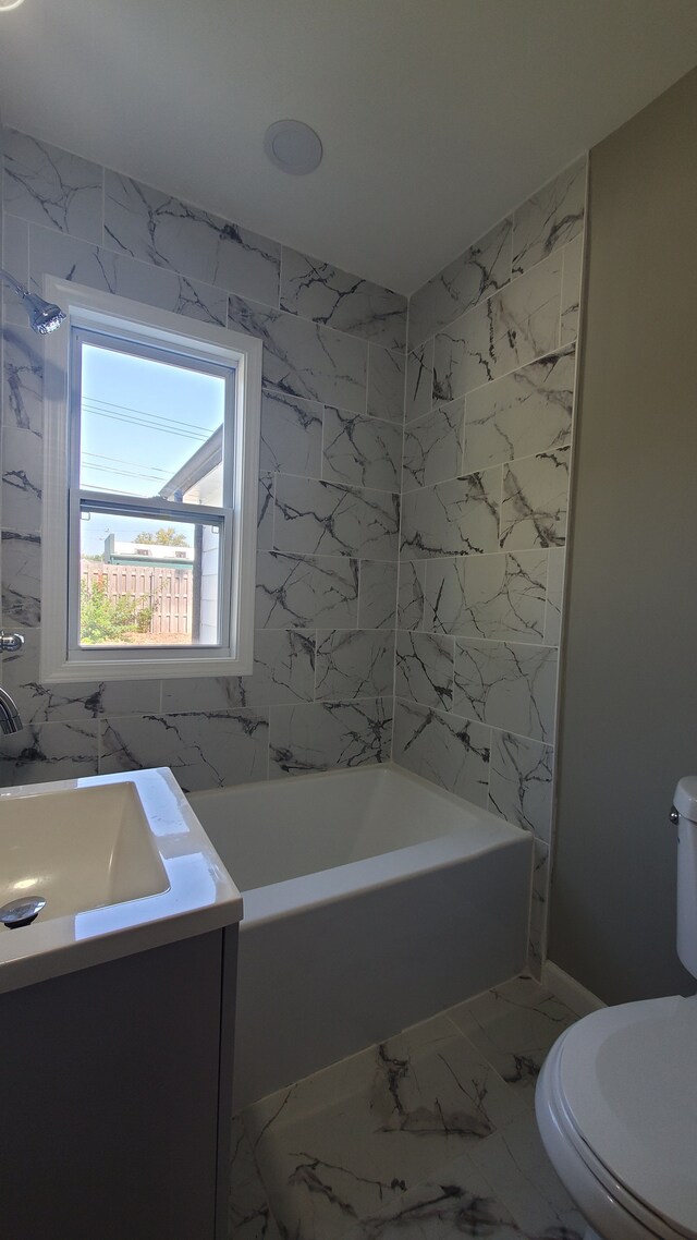 bathroom featuring a tub, toilet, and vanity