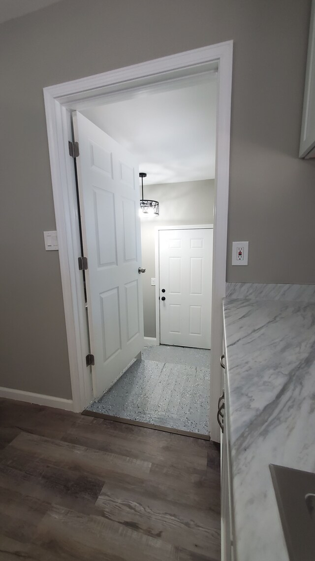 doorway to outside with dark wood-style flooring and baseboards