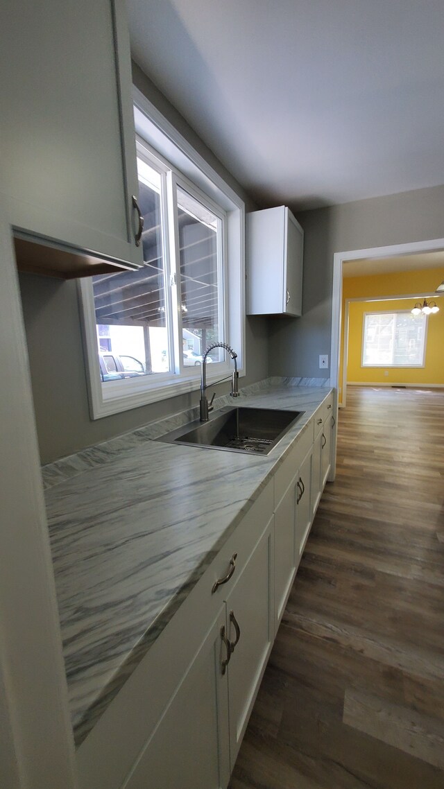 kitchen featuring plenty of natural light, a sink, white cabinets, and dark wood-style floors