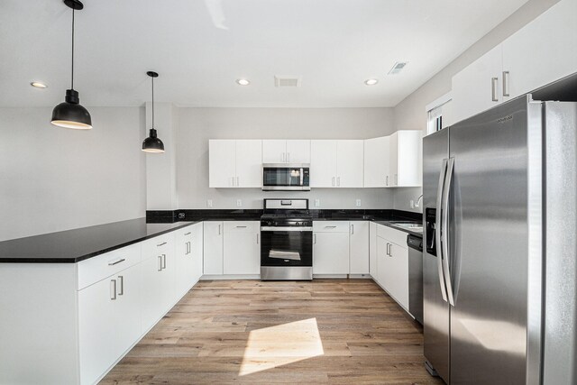 kitchen featuring sink, hanging light fixtures, light hardwood / wood-style floors, white cabinetry, and stainless steel appliances