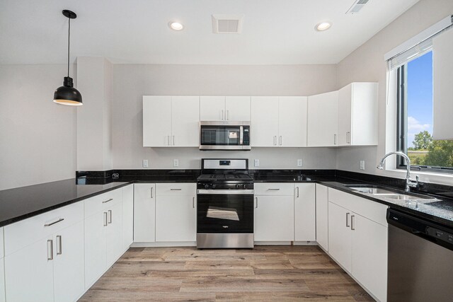 kitchen featuring white cabinets, pendant lighting, sink, and stainless steel appliances