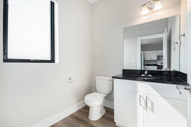 bathroom featuring hardwood / wood-style flooring, vanity, and toilet