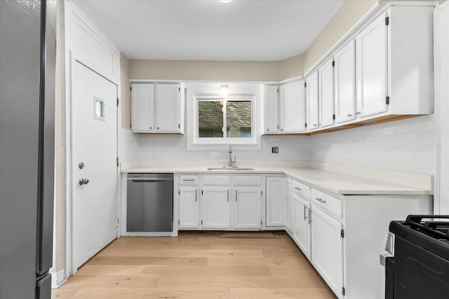 kitchen with white cabinets, appliances with stainless steel finishes, light wood-type flooring, and sink