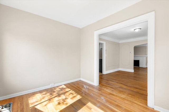 unfurnished room with hardwood / wood-style flooring and crown molding