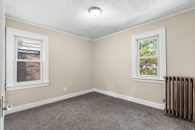 carpeted empty room with radiator heating unit, a textured ceiling, and ornamental molding