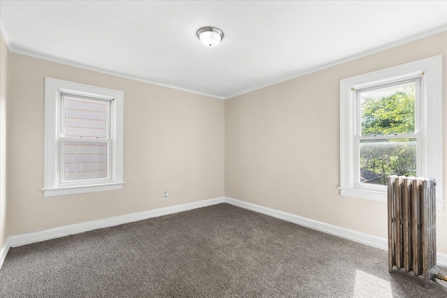 carpeted spare room featuring radiator and crown molding