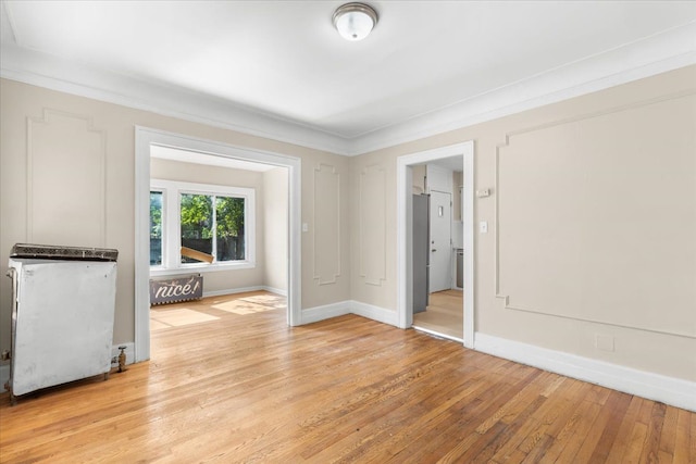 unfurnished room with crown molding and light hardwood / wood-style floors