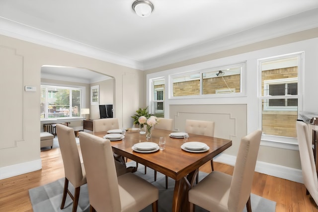 dining room with light wood-type flooring and ornamental molding