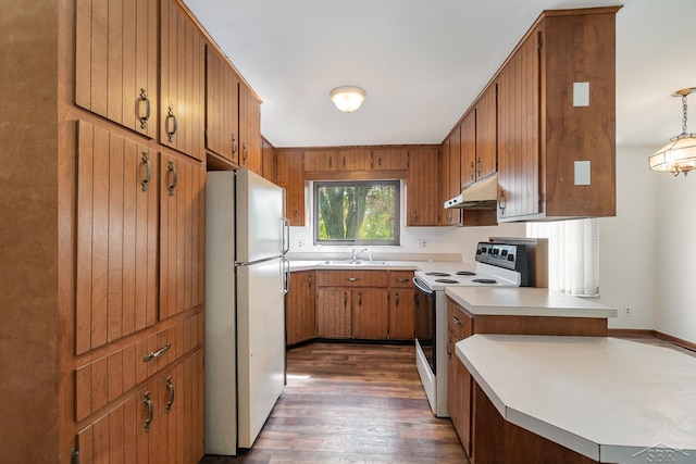 kitchen with pendant lighting, white appliances, sink, dark hardwood / wood-style floors, and kitchen peninsula