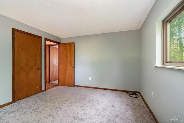 unfurnished bedroom featuring a textured ceiling and carpet floors