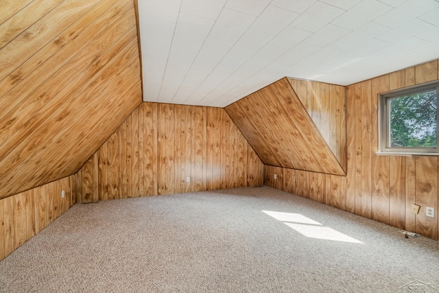 bonus room featuring carpet floors, vaulted ceiling, and wood walls