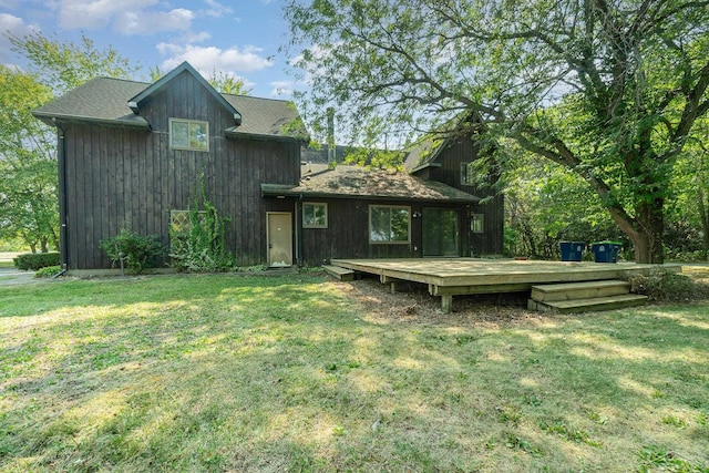 back of property with a yard and a wooden deck